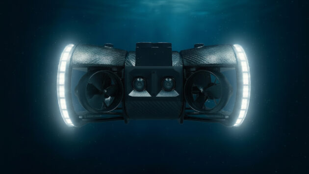 Underwater exploration drone with two side propellers, central camera housing, and glowing ring lights, submerged in dark blue water