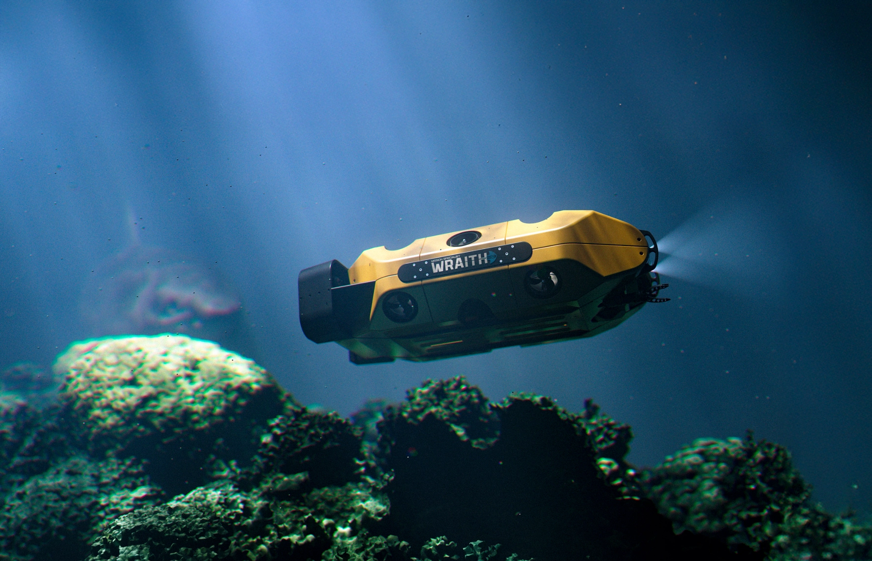 Yellow underwater drone labeled 'WRAITH' gliding over a coral reef in clear blue water, lights emitting from its front.