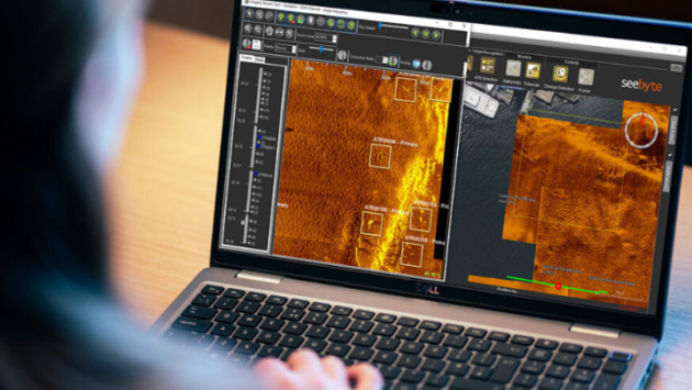 Person analyzing thermal imaging data on a laptop, with orange heat-map screens and seebyte branding visible on the interface.