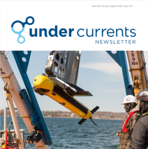 Under Currents Newsletter header logo; a yellow remotely operated vehicle is hoisted by a blue crane over the sea with crew nearby.